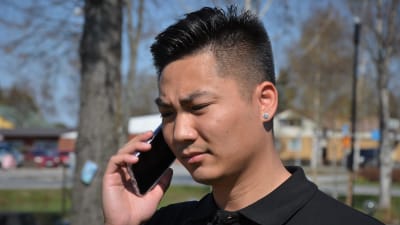 Ung man med vietnamesiskt ursprung i telefon