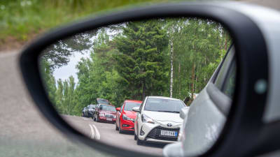 Bilar syns i en bils sidospegel.