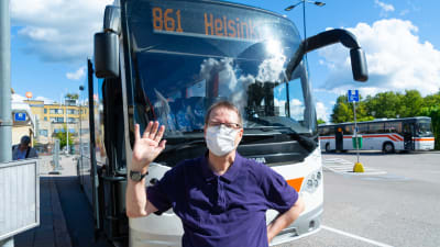 En man framför en buss.