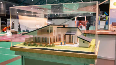 En miniatyrmodell av ett bostadshus i en glasmonter