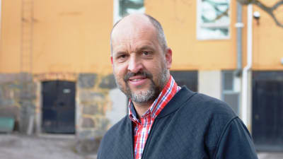 Ett porträtt på en man iklädd skjorta och tröja. Mannen heter Sture Lindholm 