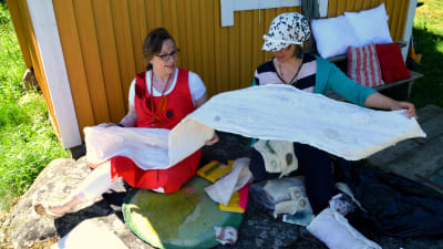 Marit Björkbacka och Sirpa Tuomaala inspekterar hantverk av ull.
