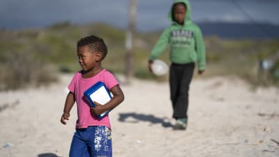 Sydafrikanska barn kommer för att hämta mat.