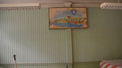 Vägg med gammal panel och skylt i stationshuset i Borgå