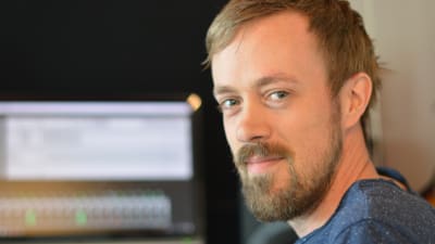 martin holm är i förgrunden. i bakgrunden finns hans dator men är ur fokus.