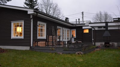 Familjens Formsans hus, ett brunt och lågt stockhus med vita smårutiga fönster. 