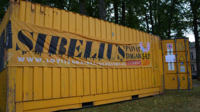 en gul container med en banderoll i en park