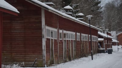 Lagerbyggnader i trä, rödmyllade, i ganska dåligt skick. Vinter och snö