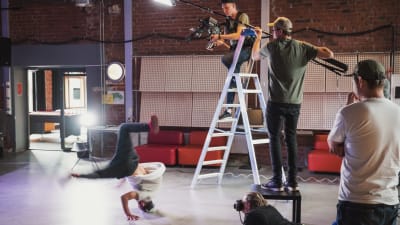 Ett kamerateam filmar en ung man som dansar breakdance.