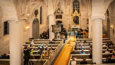 Konstnärliga ledaren för Lux Musicae Helena Juntunen sjunger i Sjundeå kyrka. Det finns publik i kyrkan, men glest utspritt eftersom konserten hölls under coronapandemin i november 2021.