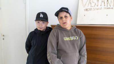 Två pojkar bredvid en träskylt som de själva gjort. Det står Västanlid och Västra Sjundeå ungdomsförening på skylten.