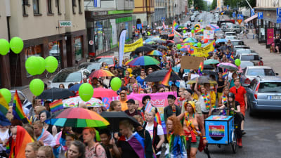 färgglada paraplyer och en massa människor som går i åbos prideparad 2018