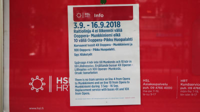 En lapp med information på finska, svenska och engelska på röd bakgrund.