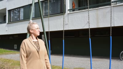 Kvinna utanför höghus.