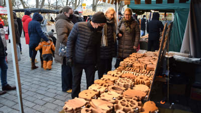 Folk som tittar på hantverk som är till salu på julmarknaden