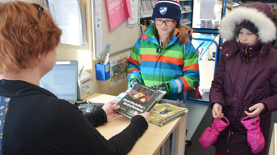 Två elever från Gammelbacka skola lånar böker från bokbussen.