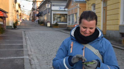 En kvinna som tittar på sin mobiltelefon. Hon heter Susanna Virtanen.