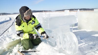 En man gör en isskulptur som föreställer en motorcykel
