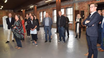 Folk lyssnar till vem som ska vinna arkitekttävlingen om Granitborgen i Hangö.
