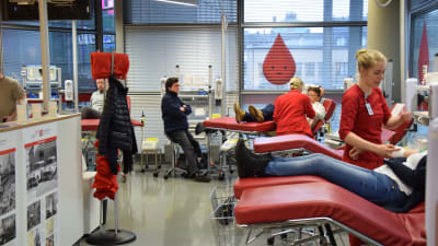 Folk utspridda på britsar för att donera blod till Blodtjänst. 