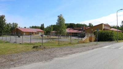Skolområde i Kaskö med gula byggnader med röda tak. På gården syns klätterställingar och gungor.