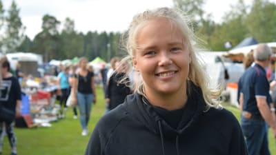 pamea pynttäri i halvbild. hon bär en mörkblå huvtröja och i bakgrunden ser man marknaden i oskärpa.