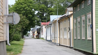 En gata med gamla trähus i olika färger.