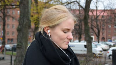 Hanna Ylöstalo lyssnar på ljudbok via sina hörlurar.