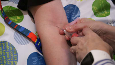 En sjukskötare tar blodprov på en kvinna. I bilden syns två händer som sticker en spruta in i armvecket.