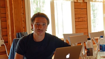 Man sitter vid en laptop.