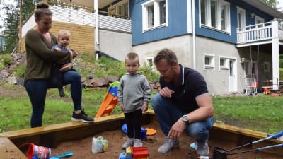 Patrik Grönberg med familj leker i sandlådan.