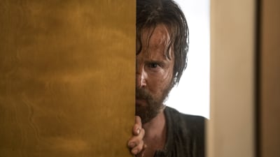 En smutsig och ärrad Jesse Pinkman (spelad av Aaron Paul) kikar fram bakom en dörr.