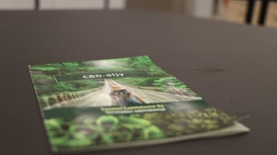 En broschyr för cannabisolja ligger på ett bord. 