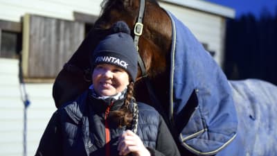 Nina Pettersson-Perklén står och håller i hästen Emil.