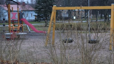 En lekpark tom på barn en höstlik, mulen och snöfri vinterdag i januari.