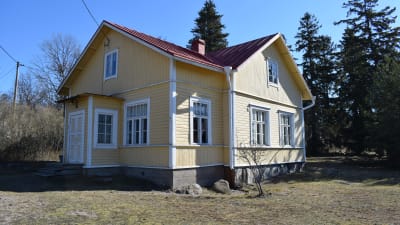Ett gult gammalt trähus med plåttak som är hitis-rosala förskola. Soligt vårväder.