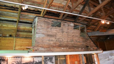 En gammal träsläde fastspänd i takkonstruktionerna i ett museum.