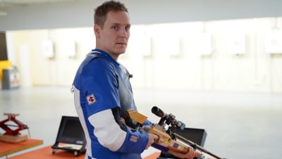 Niklas Hyvärinen står med ett gevär i händerna.