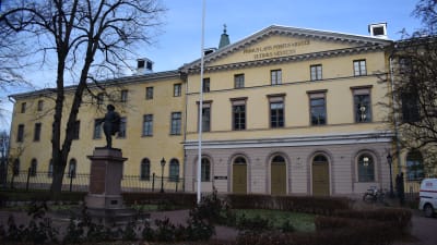 Åbo hovrätt består av en stor gul byggnad i tre våningar. Framför huset står en staty i parken.