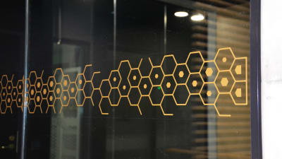 En guldfärgad fönsterdekoration som har formen av molekyler. 