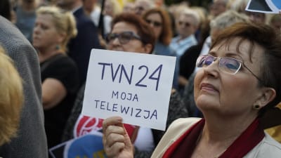 En kvinna håller upp en skylt där det står TVN24, min television.