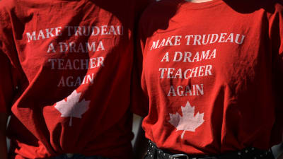 Två demonstranter bär skjortor med texten "Gör Justin Trudeau till dramalärare på nytt"