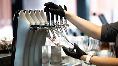 En person fyller ett ölstop på en restaurang.