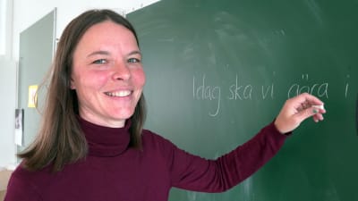 Heidi Hafrén-Holmberg skriver på en tavla i ett klassrum i Seminarieskolan i Ekenäs. 