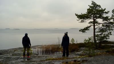 Sarah Grönstrand och Johanna Sandin står på klipporna med ryggen åt och tittar ut mot dimmigt hav. 