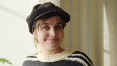 En bild på en kvinna i hatt och tröja.