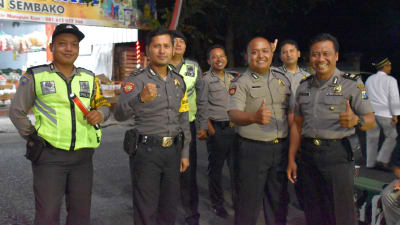 Sju indonesiska poliser står på rad i Indonesien. Två av dem visar tummen upp.