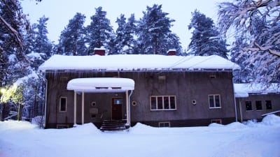 En rappad byggnad täckt med snö. 
