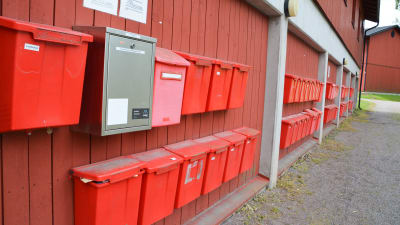 en lång rad med röda brevlådor utan namn