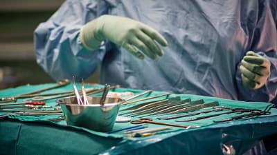 Kirurgiska instrument upplagda på bord i operationssal. 